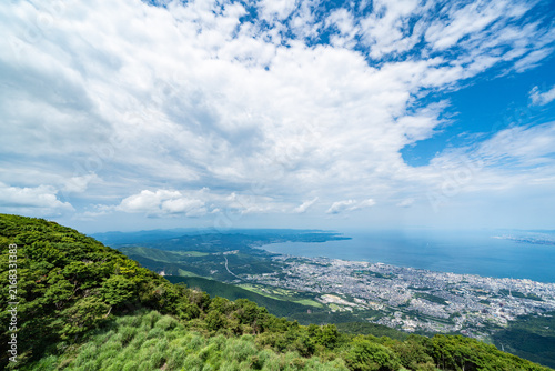 Bild auf Leinwand Panoramic aerial view of Beppu city and Beppu bay under blue sky with clouds fro