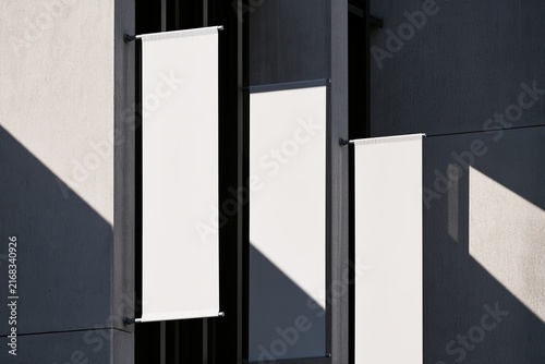 Blank white banners hang vertically on a modern building exterior