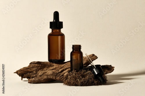 Amber glass dropper bottles on weathered wood, natural essence