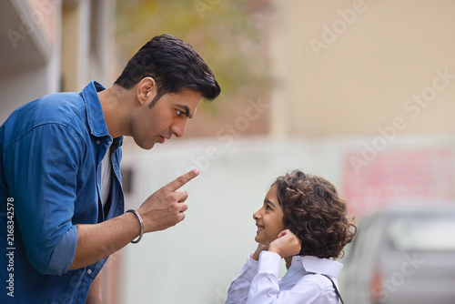 Little school boy apologizing to his father for the mistake