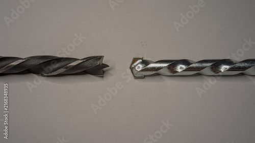 Cuadro en lienzo Two different drill bits side-by-side on a plain white surface, a wood brad poin