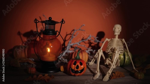 Slow push in on candle lantern, pumpkin and skeleton scene for Halloween party decor, spooky backdrops and autumn design