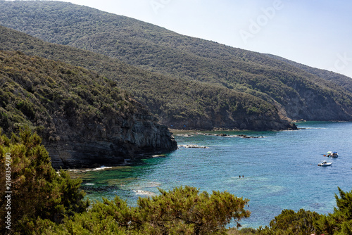 Scenic coastal landscape at Buca delle Fate near Populonia, Tuscany, Italy, with rocky cliffs, Mediterranean vegetation, green hills and blue sea. 