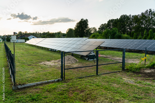 View of solar panels installed in a fenced field during the golden hour in Dabrowa Gornicza, Silesian Voivodeship, Poland.