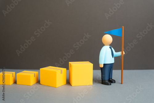Bild auf Leinwand A businessman leads a chain of boxes with goods