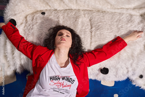Stylish woman exhibiting trendy outfit on plush sofa for photography