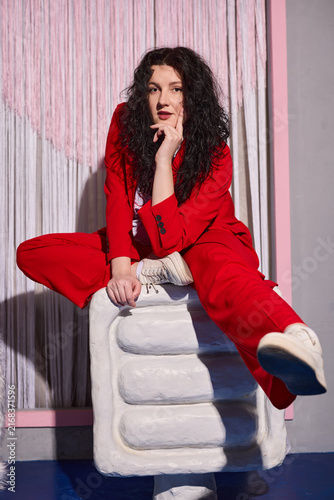 Glamorous caucasian model in red suit, editorial fashion