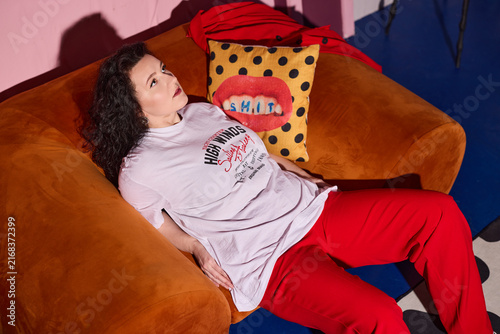Woman resting comfortably on sofa with fashionable attire
