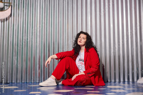 Industrial styled portrait of thoughtful woman in striking red suit