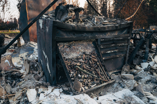 View of a charred metal tool chest filled with scattered sockets and tools amidst the debris of a wildfire in Spokane, Washington, United States.
