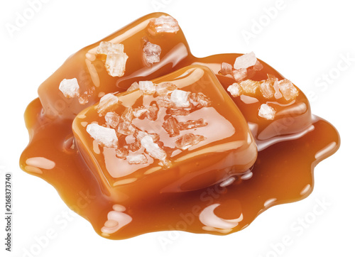 Salted caramel candies topped with sea salt crystals and liquid caramel drizzle for gourmet confectionery, with clipping path.