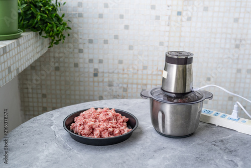 Foto A plate of minced pork and a meat grinder.
