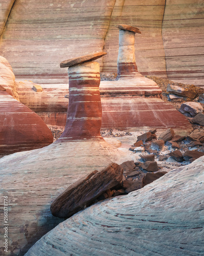 View of unique sandstone hoodoos with layered rock textures and natural stone caps in the desert landscape of Kanab, Arizona, United States.