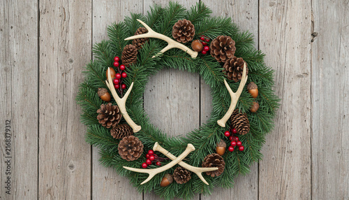 Christmas wreath with antlers on rustic wood background
