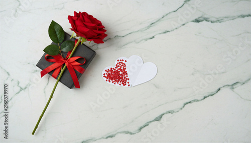 Red rose and gift box with paper hearts