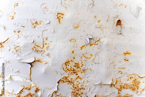 фотографія Cracked white painted metal surface with rust spots, peeling paint texture, and green drops, representing material wear, corrosion, and weathering