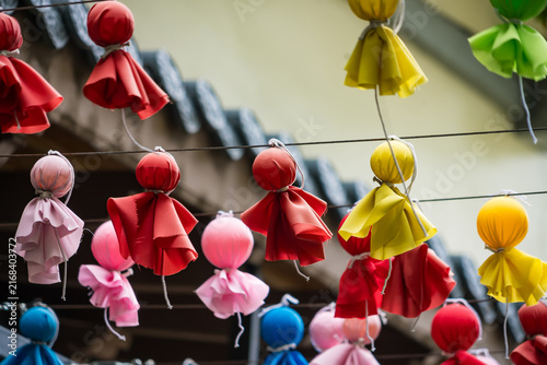 Foto Colorful Handmade Dolls Hanging: A vibrant display of handmade cloth dolls, each with unique fabric patterns and bright colors, are strung together, creating a whimsical and festive atmosphere