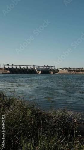 Hydroelectric power station and dam standing across a river. For documentaries on renewable energy,  presentations on clean power generation, environmental reports, or industrial infrastructure.