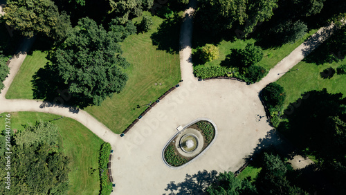 Top-down aerial view of a circular fountain and geometric pathways in a green city park, lithuania travel content, urban park design marketing, landscape architecture photography, city guide imagery