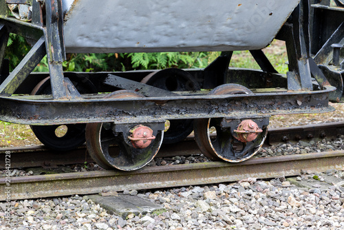 Foto Narrow gauge wagon wheelset on rail track with rusted axle and steel wheels visible