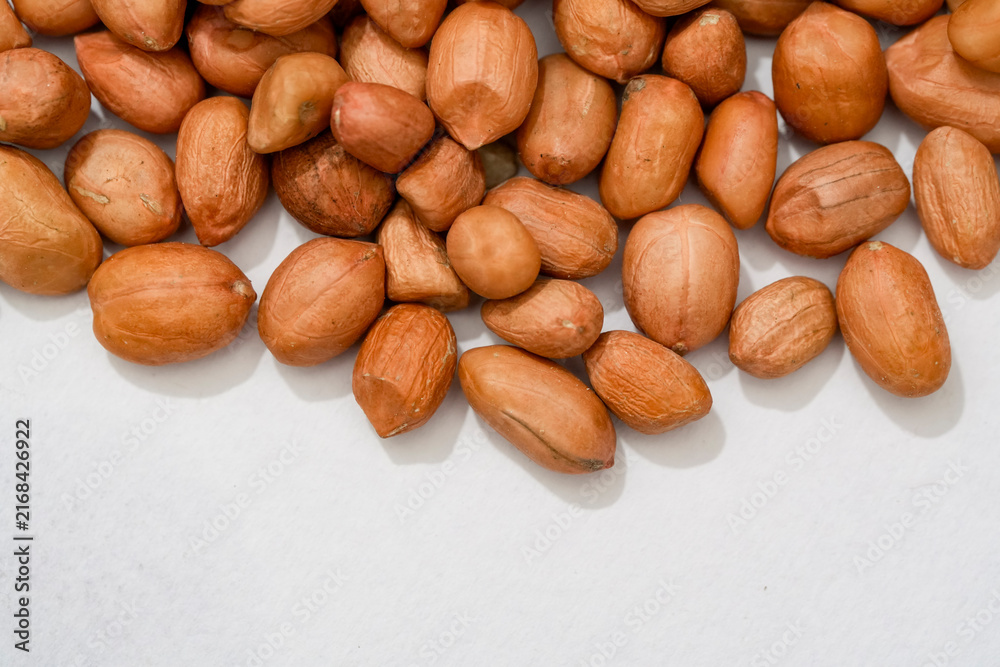Obraz premium Raw peanut kernels in brown peel in close-up White Background