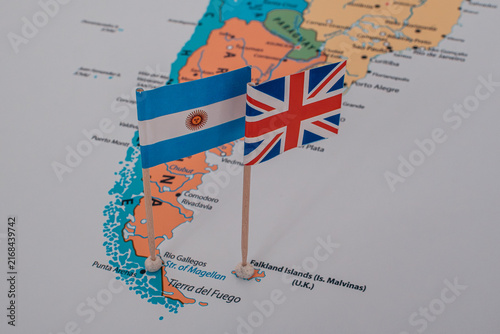 Miniature flags of Argentina and Great Britain pinned on a map over Argentina and the Falkland Islands.