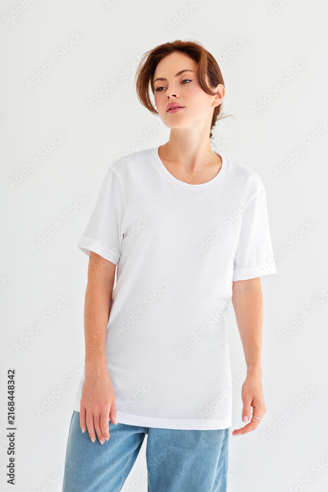 Obraz premium Blank white t-shirt mockup on woman standing in studio