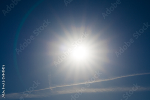 Bright sunlight in the clear sky with a contrail line, summer sun in the sky over 27798 Hude, Germany