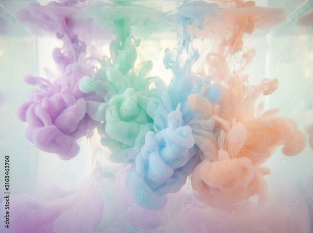 Obraz premium Gentle pastel inks diffuse beautifully in clear water forming captivating fluid shapes. This ethereal and vibrant abstract background is ideal for art design and creative projects.