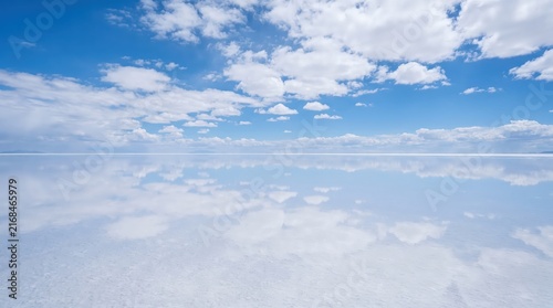 Vast Tranquil Salt Flat Under Bright Blue Sky with Fluffy White Clouds