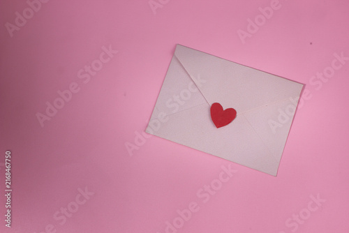 Foto Pink envelope with a red heart symbol on a clean background, representing a Vale