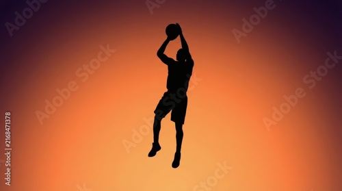 Basketball player silhouette jumps into the air to shoot the ball against a vibrant sunset sky background.