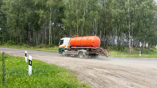 Vacuum truck for wastewater treatment.  Sewage truck turns onto the road to a farm.