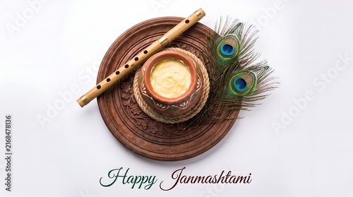 A festive janmashtami display with makhan pot, flute, peacock feathers and decorative golden frame