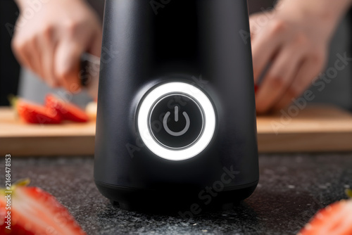 Extreme close-up of the matte plastic buttons and LED ring of a rechargeable portable blender.