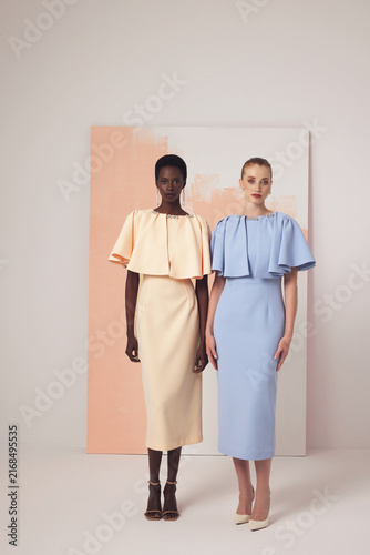 Fotografía Two diverse female models in pastel matching dresses with ruffled cape bodices