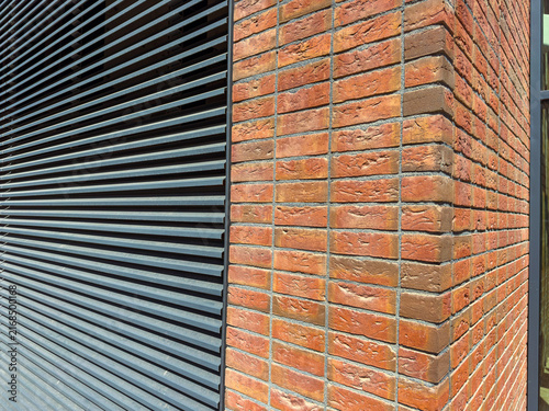 Photography Brick and metal wall design shows a corner of a building in bright sunlight with