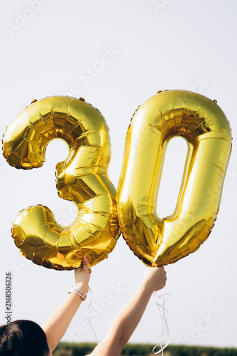Golden foil balloons in the shape of number 30 for a thirtieth birthday party