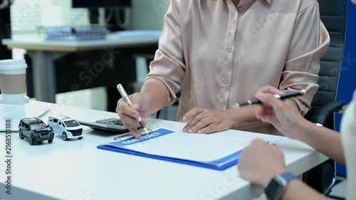 Car insurance consultation using smartphone and documents. Advisor and customer reviewing digital insurance service, auto policy, finance