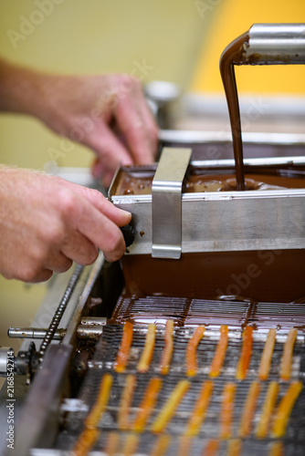 Konstfotografi Le chocolat chaud coule sur le tapis recouvert d'écorces d'orange pour faire de