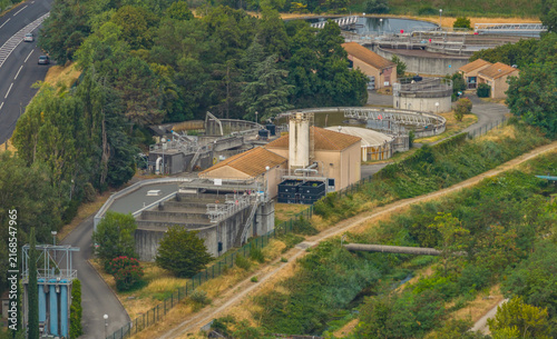 Aerial view of a wastewater treatment plant with settling tanks, processing basins, and water management infrastructure in Portes-les-Valence, Auvergne-Rhone-Alpes, France.