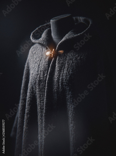Dark hooded wool cloak with wooden toggle clasp, mysterious fantasy garment on mannequin