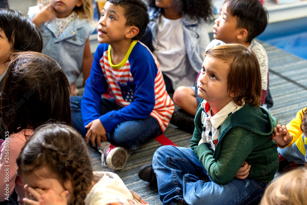Fototapeta premium Diverse children engaged storytelling session.