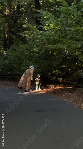 Mother helping child on forest path