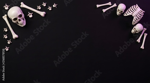 Human skulls and bones arranged as a frame on a solid black background for halloween