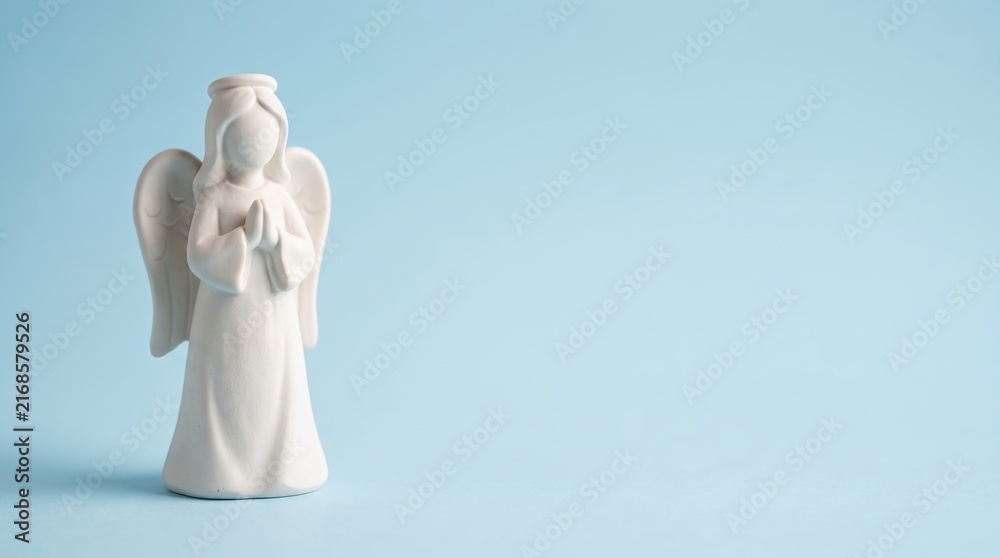 Fototapeta premium White angel figurine on blue