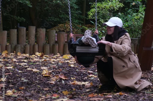 Mother photographing son in autumn park