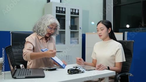Car dealer agent shows color palette swatches and explains loan agreement contract to senior female buyer