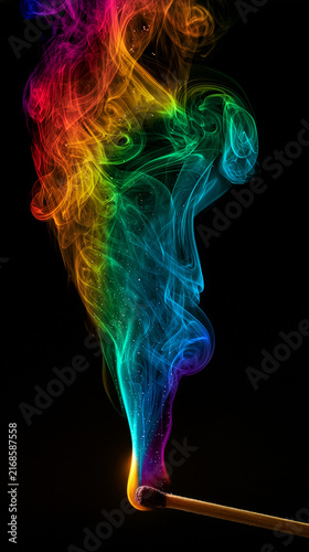 a single burning wooden matchstick with rainbow-colored smoke  isolated on black background