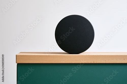 Simple geometric composition with a round object on a wooden surface